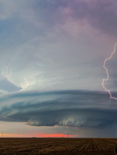 A bolt of lightning strikes ahead of a beautifully sculpted mesocyclone on a storm near Sublette, Kansas on May 21, 2020