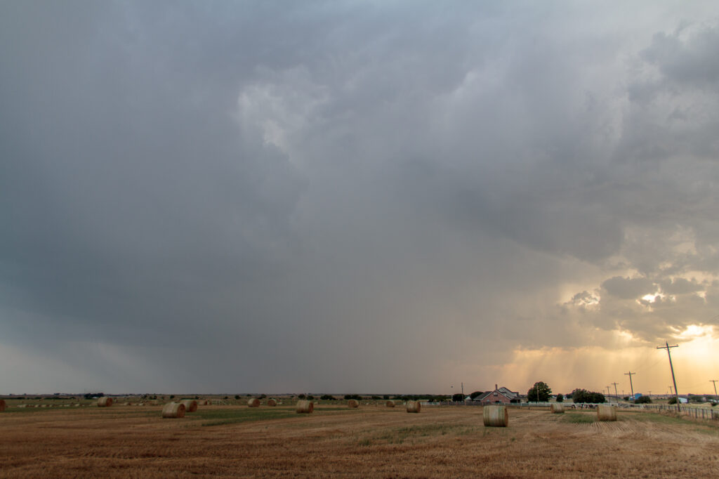 Storm over field with hay bales