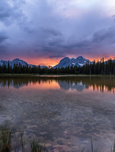 The sun sets over a pond in Spray Valley Provincal Park in Alberta, Canada.