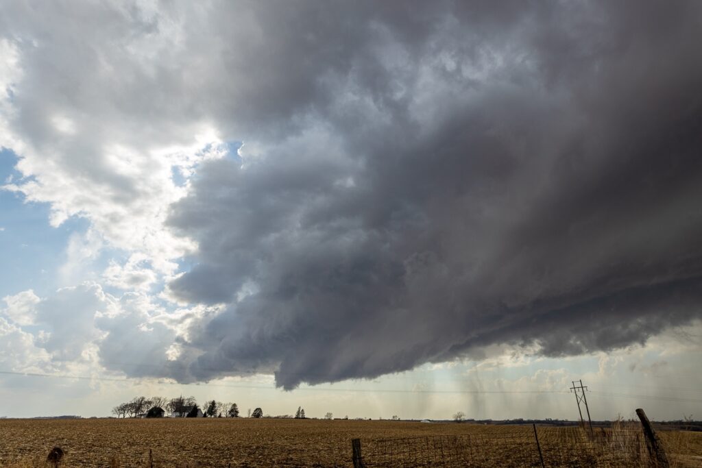 A church steeple in the distance with a supercell storm base above it near Clarinda Iowa